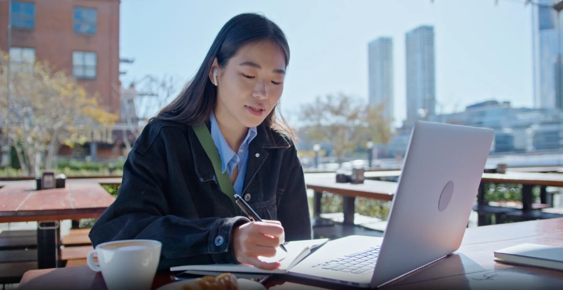 Two colleagues looking at a laptop together.