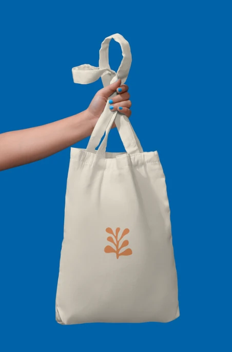 The tote held up against a deep blue background.