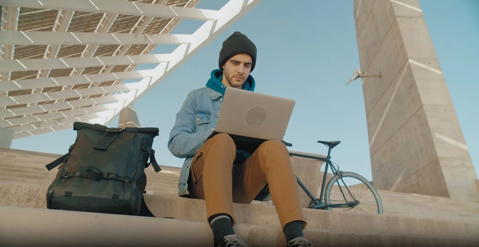A staff member with a laptop on the steps.