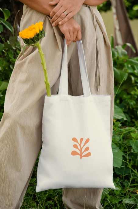 The tote carried through a garden with a sunflower.