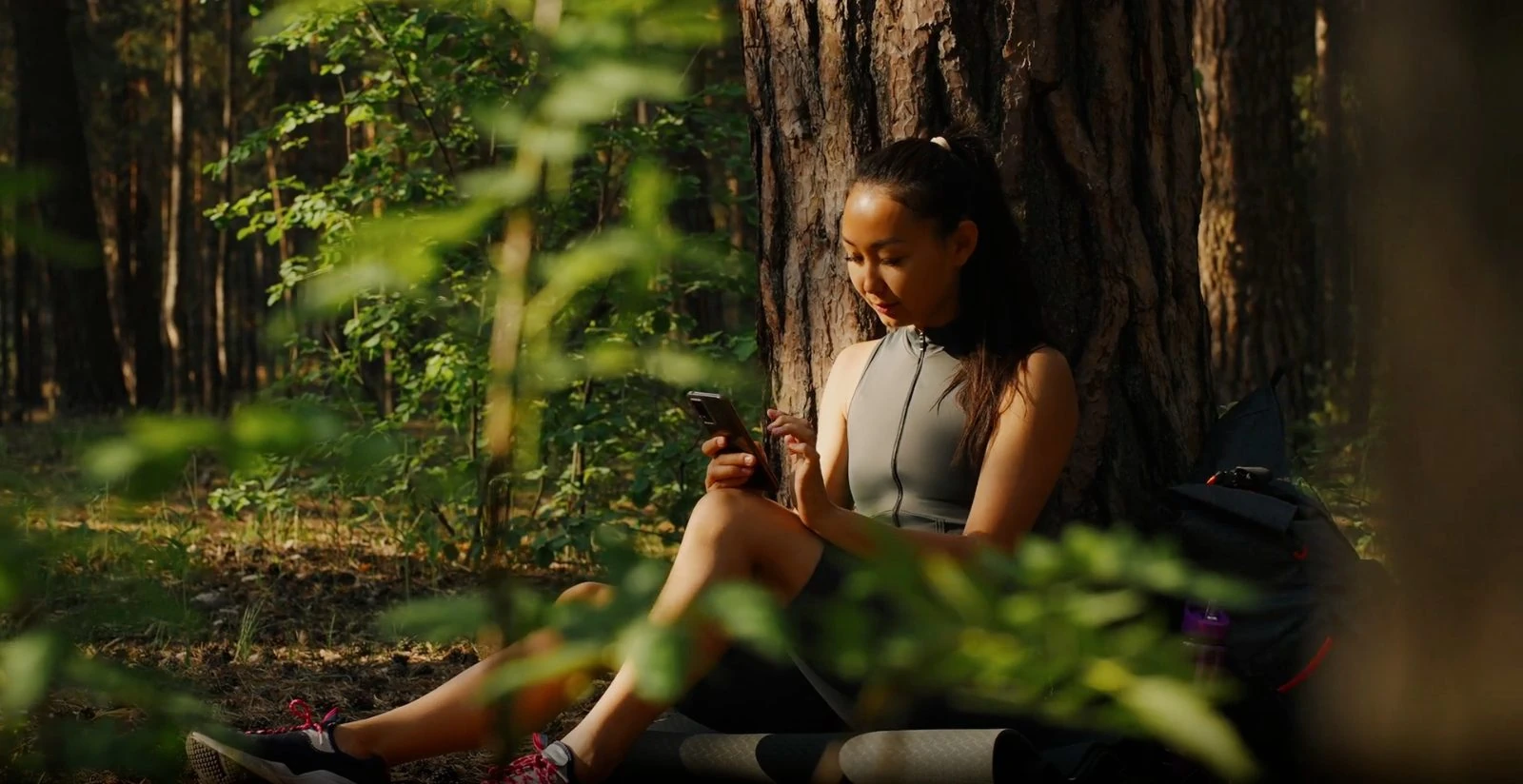 A student on the phone among the trees.