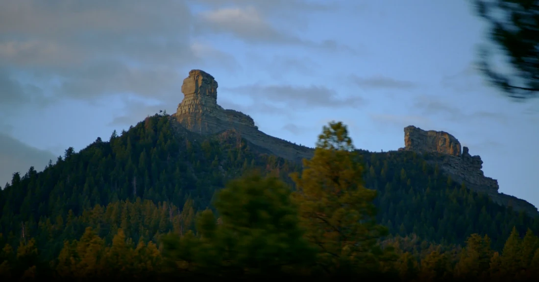 A granite ridge above forested valleys in morning light.