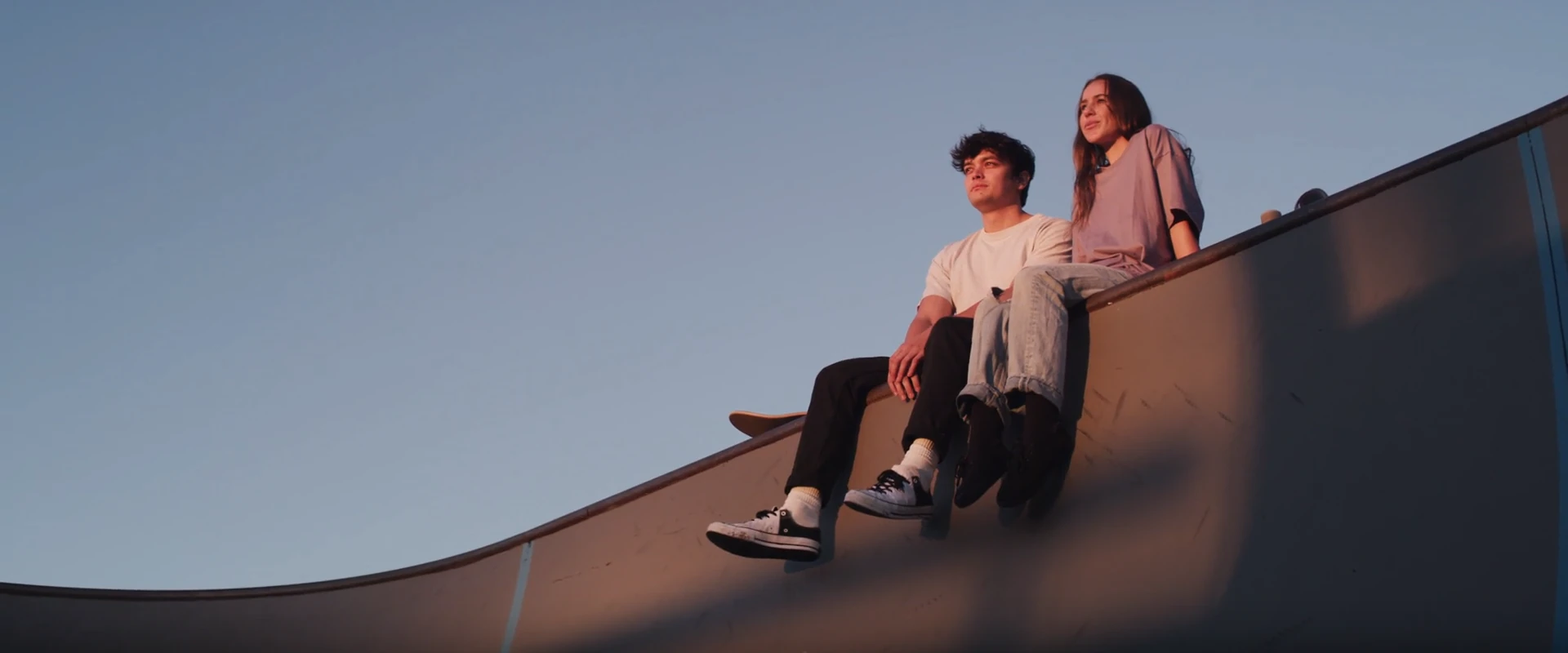 A student at the top of a skate ramp.