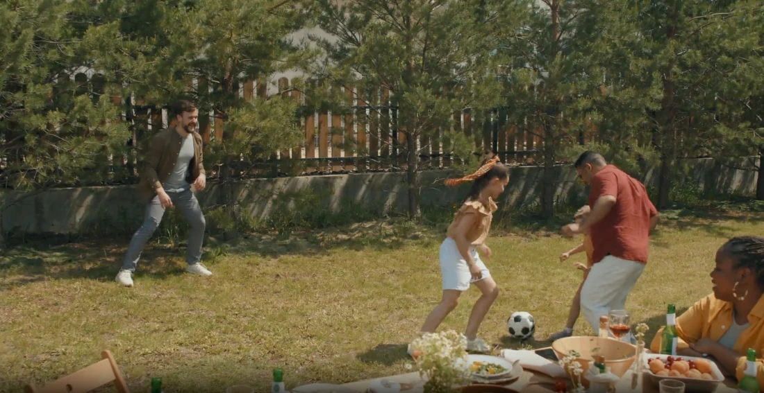 A family playing football in the garden.
