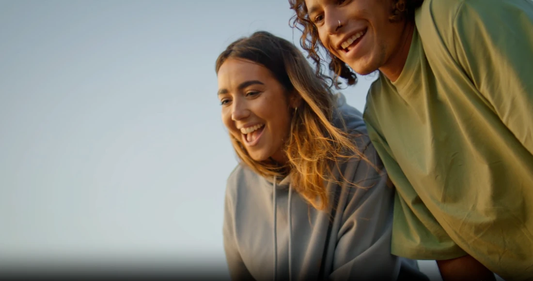 Two students laughing together outdoors.